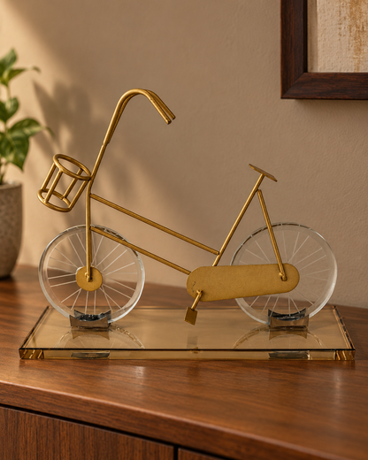 Gold Promenade bicycle sculpture with crystal-glass wheels and a reflective amber-tinted glass base
