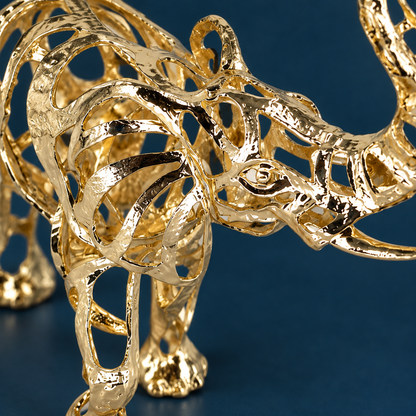 Close view of the Warm Gold elephant's openwork ear, head and reflective alloy finish