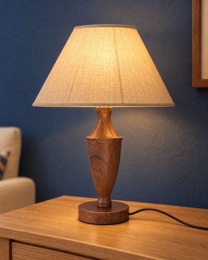 Vase wood-look metal table lamp illuminated through its cream fabric shade