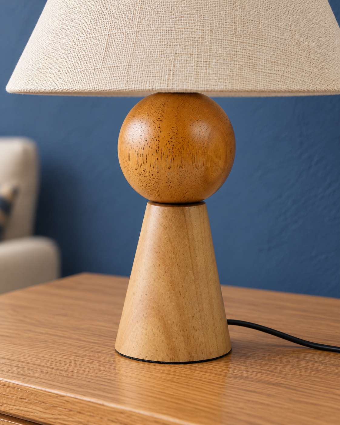 Close-up of the Orbit lamp wooden sphere, tapered base and natural grain